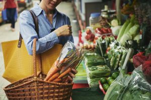 seorang wanita membeli sayur-sayuran di pasar
